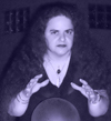 trying for a witchy vibe, this photo has a slight blue violet tint, it's a night and I'm lit from below holding my hands over some round thing with a serious expression, the round thing is the top of a waist high light and I thought pretending it was a witchy thing would be a fun photo